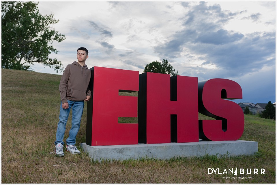 kaden standing next to EHS eaglecrest high school sign