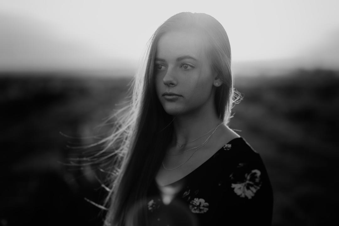 black and white of a high school senior at sunset